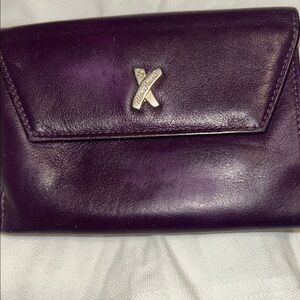 vintage Paloma Picasso purple leather bifold wallet with signature "X" logo.